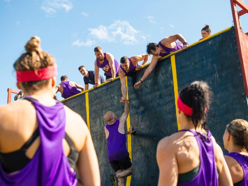 obstacle race pulling team mate over wall raw challenge